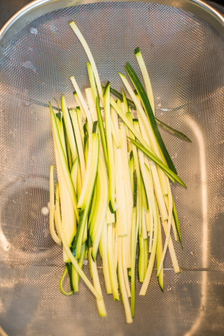Strips of courgettes in a colander. 
